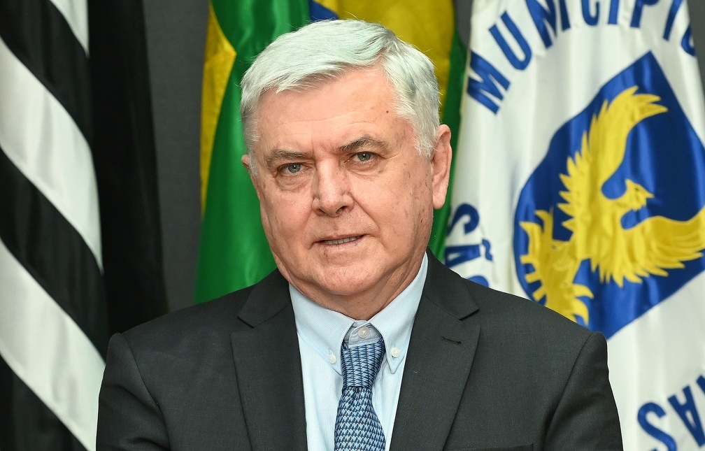 Fotografia do secretário Lair Zambon, em pé, com bandeiras de Campinas, do Estado de São Paulo e do Brasil ao fundo.