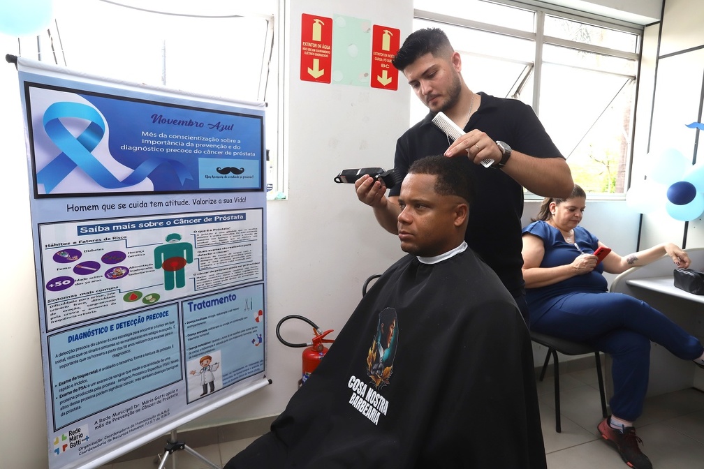 Beleza e informação: corte de cabelo ao lado do banner com as informações sobre câncer de próstata