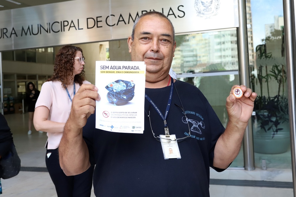 Quem passava pelo local era abordado e recebia um folheto com informações, além de um broche da Brigada da Dengue