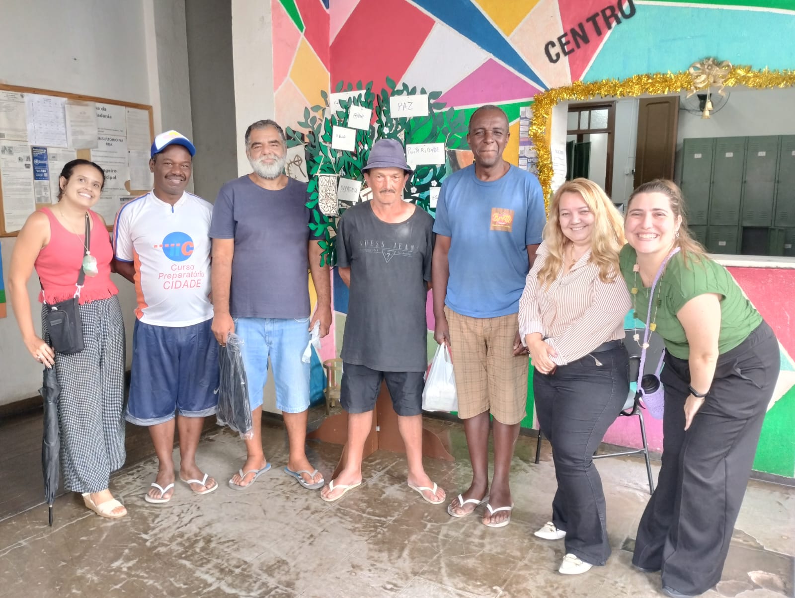 Usuários e equipe do Centro POP Sares II em frente à "árvore de palavras" que expressa desejos e metas de cada um