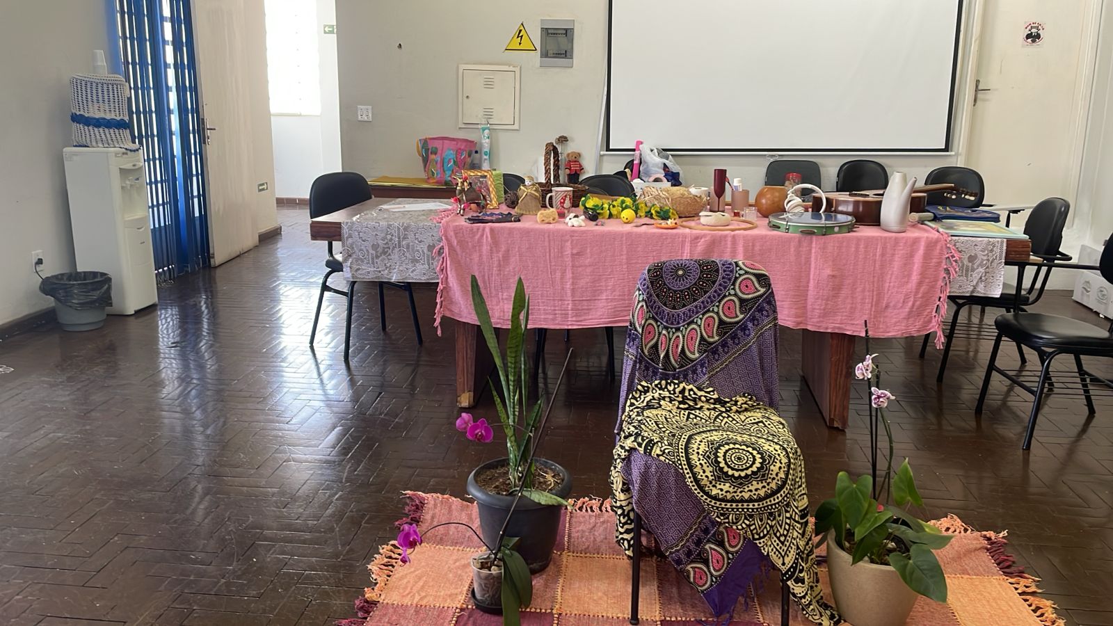 Escuta sensível: na atividade “Tenda do Conto”, cada participante escolheu um objeto disposto sobre uma mesa cuidadosamente preparada, com flores, instrumentos e tecidos coloridos, para compartilhar lembranças, sentimentos ou aprendizados