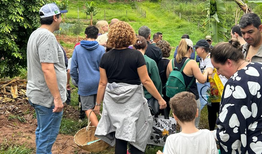 Crianças e adultos percorrem a agrofloresta em atividade educativa que integra natureza, alimentação e sustentabilidade
