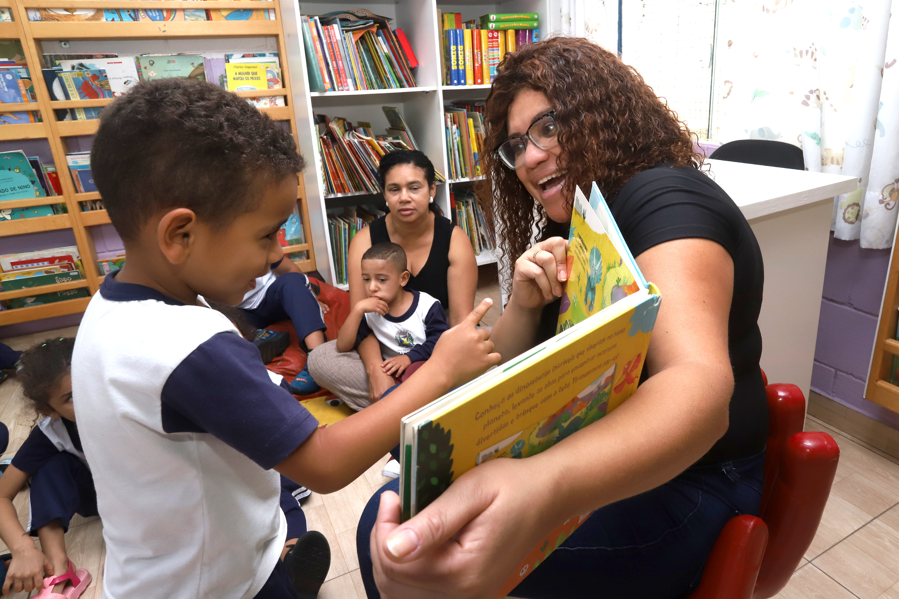 Professora interage com aluno em atividade de leitura; Educação é uma das áreas contempladas com nomeações