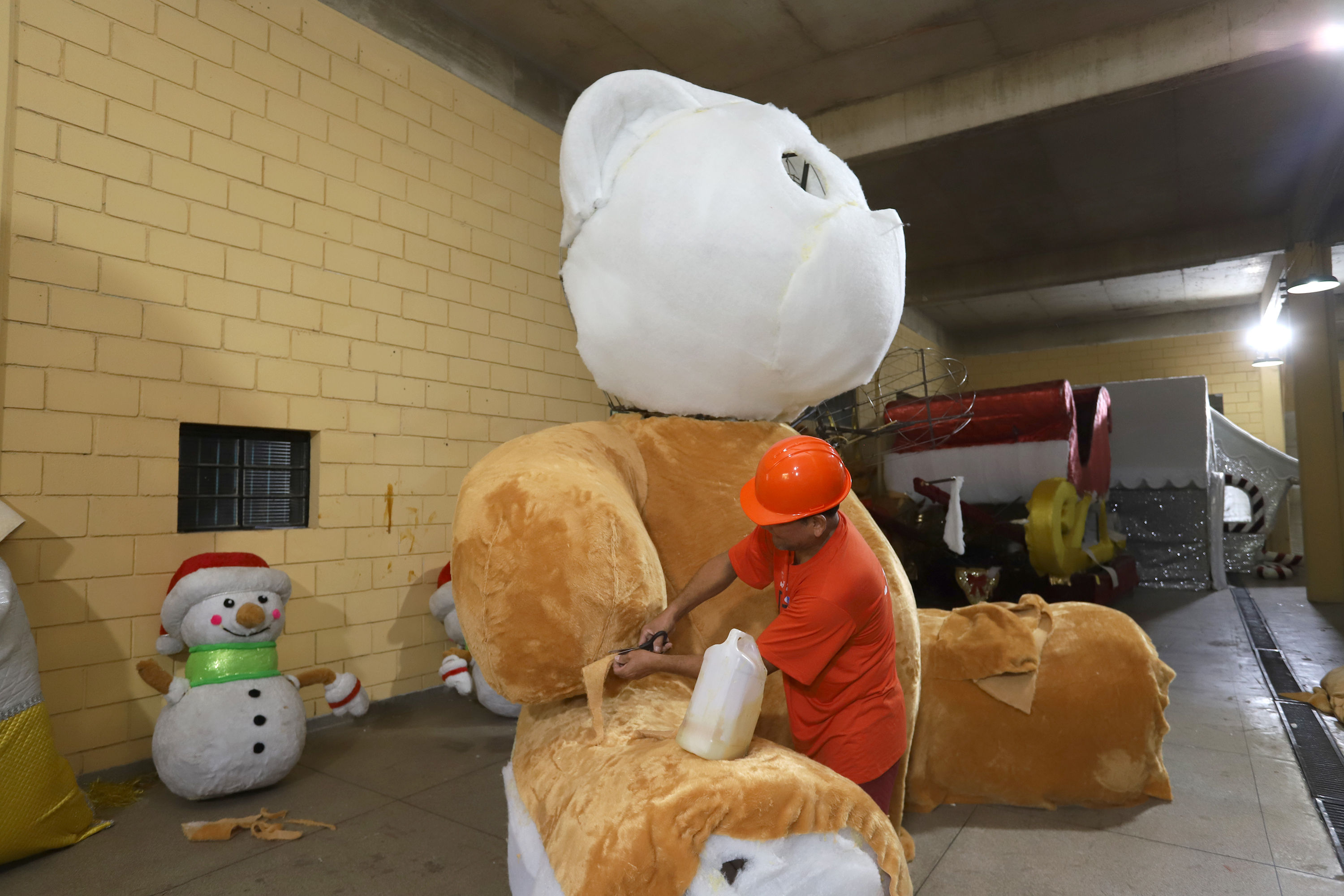 Homem trabalha na confecção de boneco para a alegoria do Natal Caminhos dos Sonhos 2024