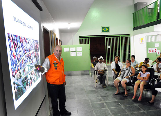Sidnei Furtado mostra esquema da simulação aos moradores