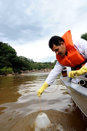 O funcionário Olávio dos Santos coleta  amostras de água para análises