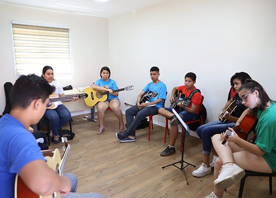 Alunos tocam instrumentos musicais no Instituto Anelo