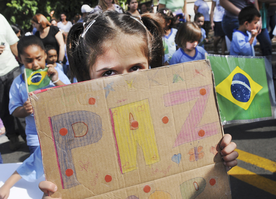 Menina segura cartaz com mensagem de paz