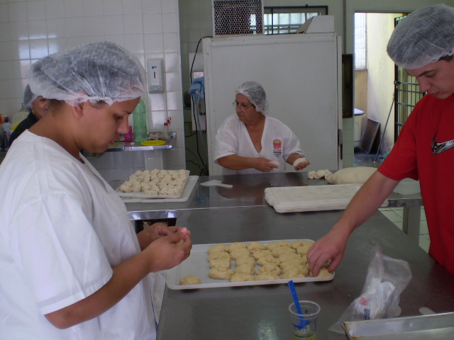 Integrantes produzem pães na cozinha
