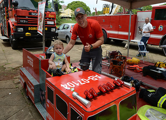 Criança conhece miniatura de carro dos Bombeiros
