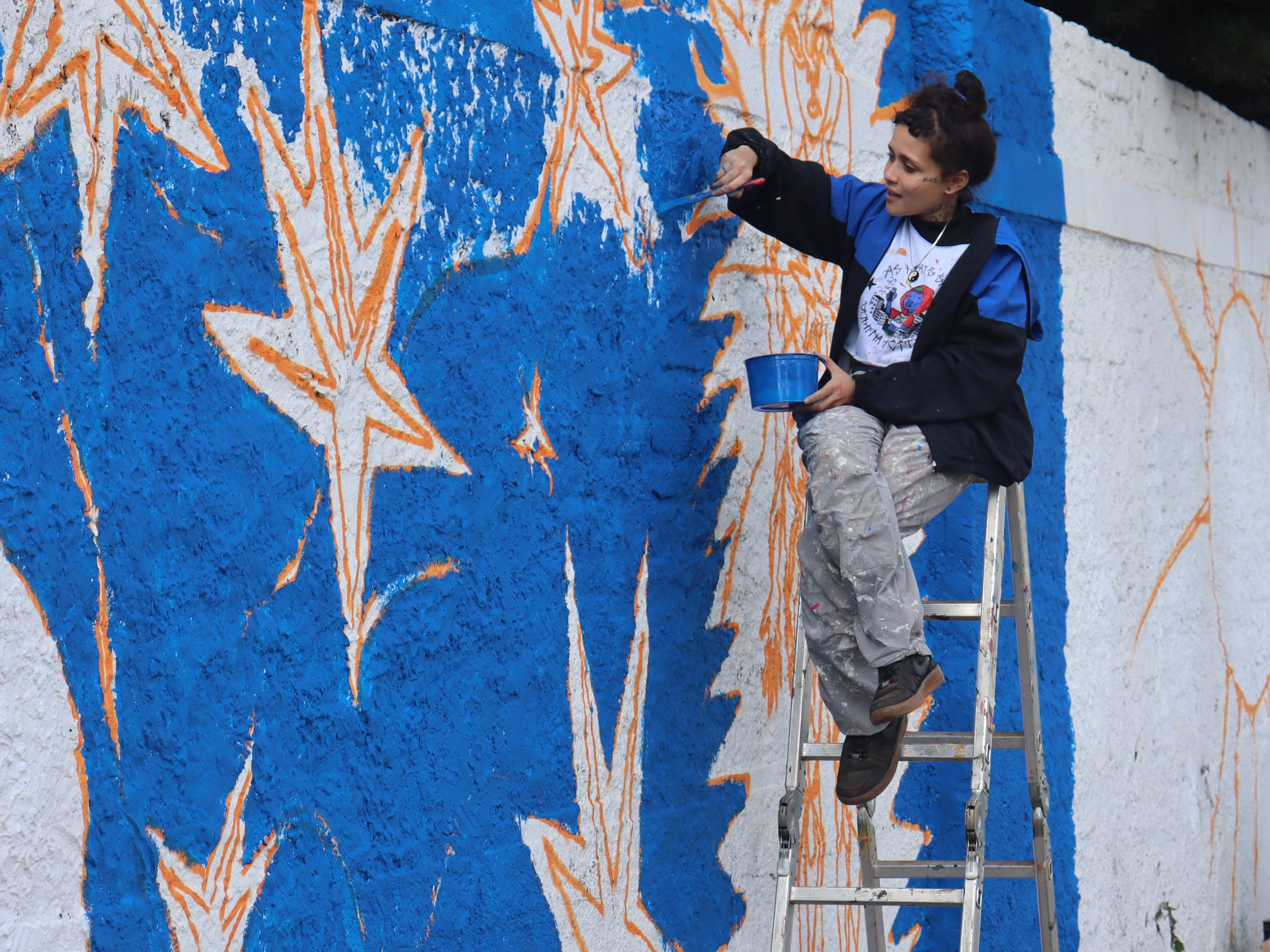Aura trabalha em muro na sede da Emdec