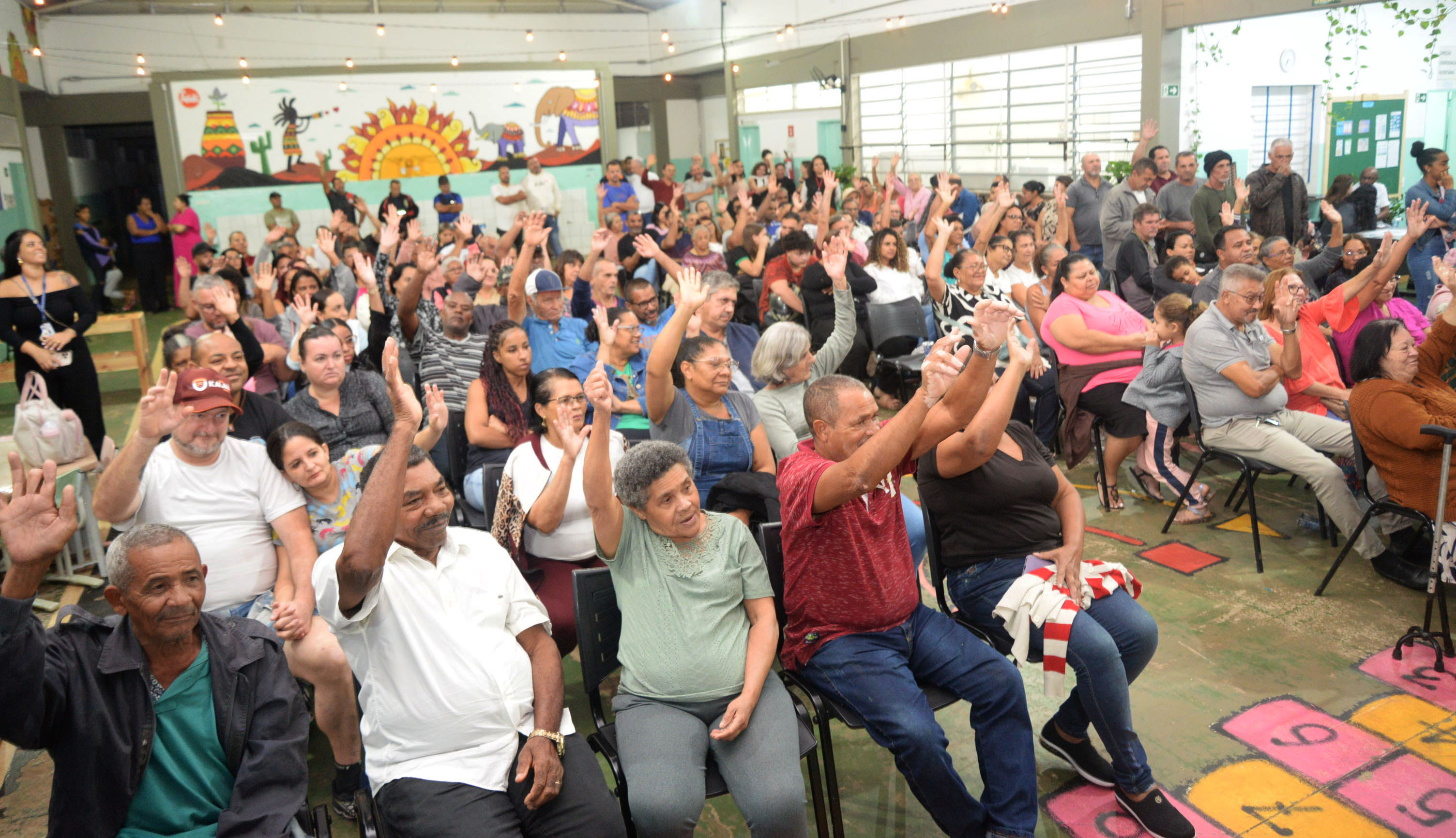 Moradores da Vila Princesa comemoram a entrega das escrituras durante cerimônia realizada no CEI Nave Mãe Zilda Arns.