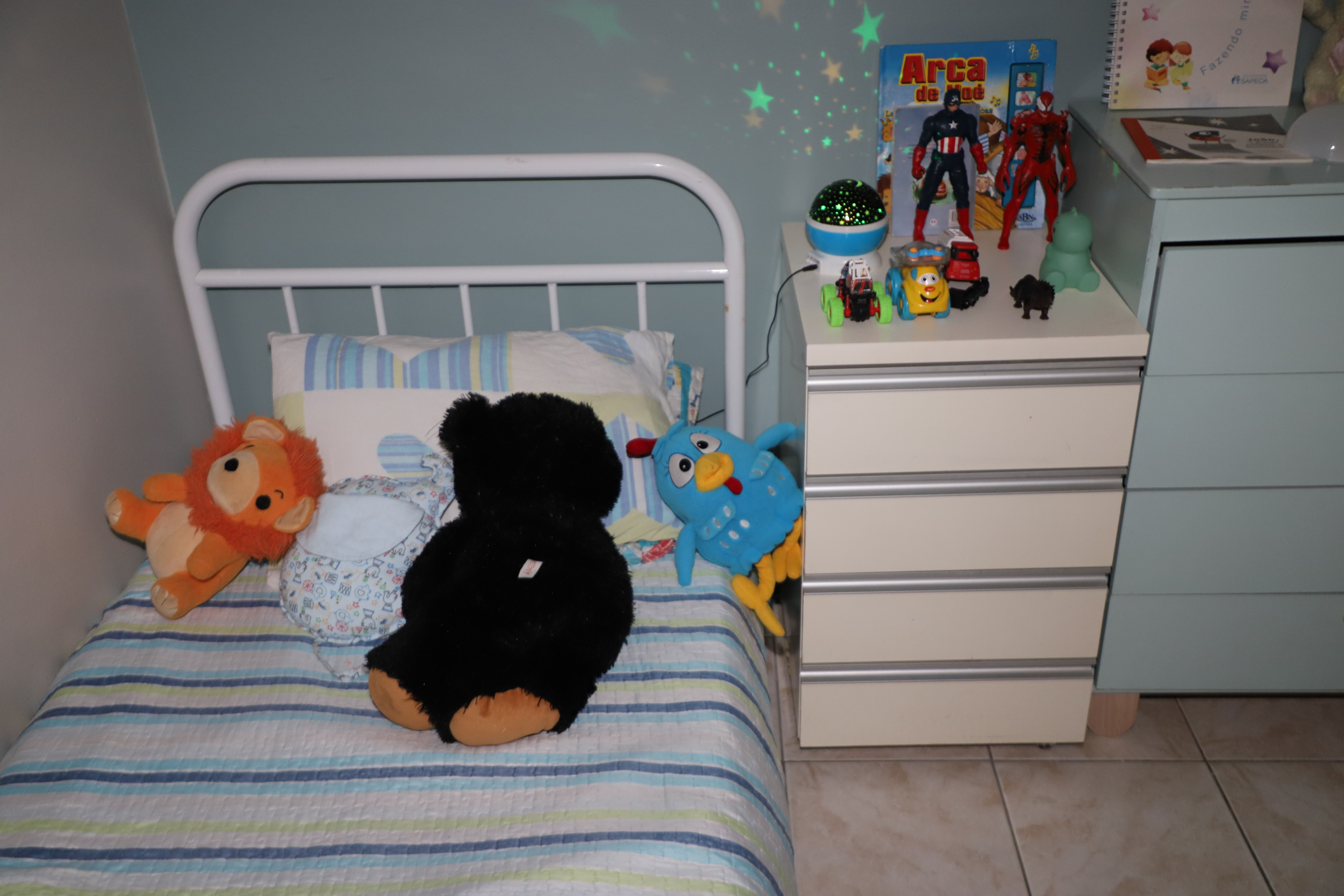 Estrelas luminosas projetadas no teto falam do carinho com que o quarto foi preparado 