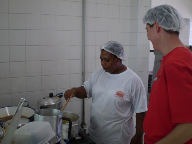 Cooperados trabalham na cozinha da padaria e confeitaria