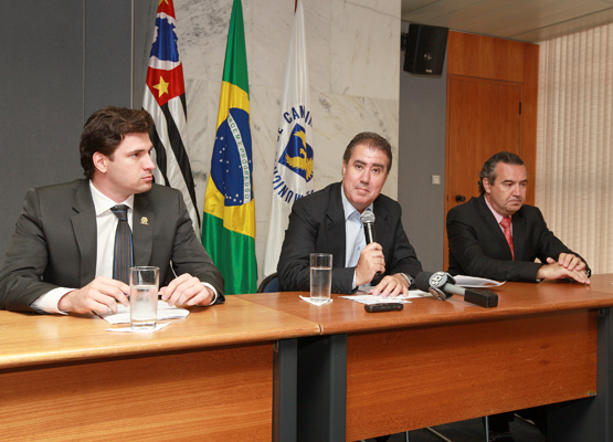 Entre o vice (esq.) e o secretário, Jonas anuncia o pacote