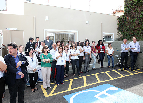Funcionários e convidados posam para foto em frente ao imóvel