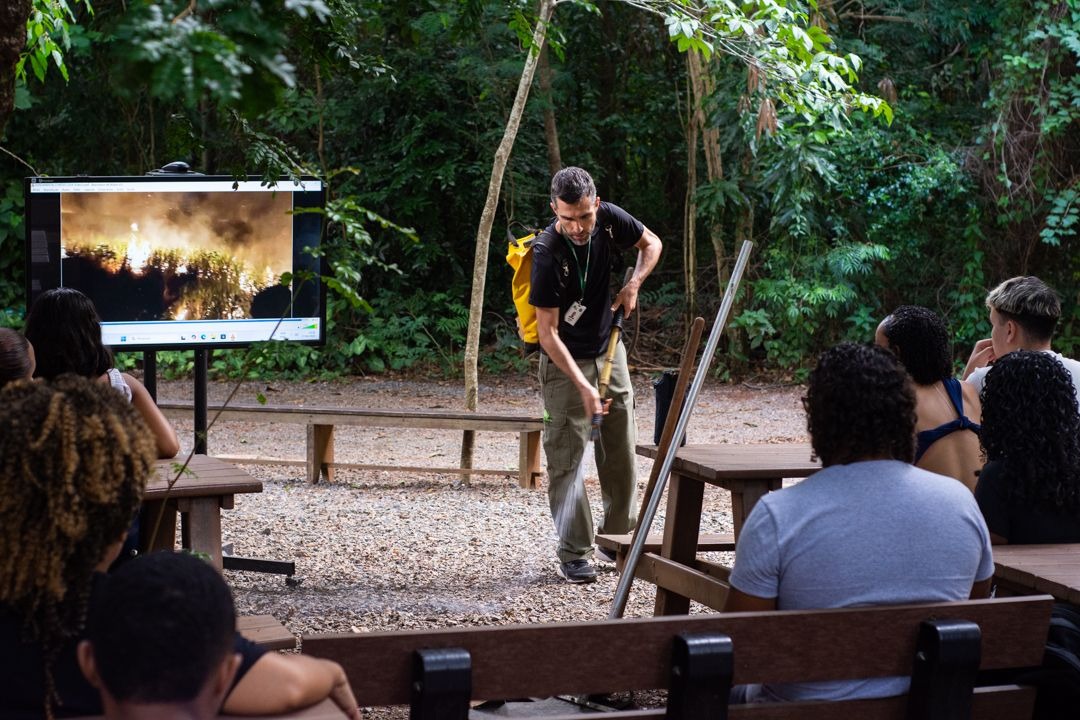 Brigadista mostra como jato de água deve ser posicionado para apagar focos de incêndio