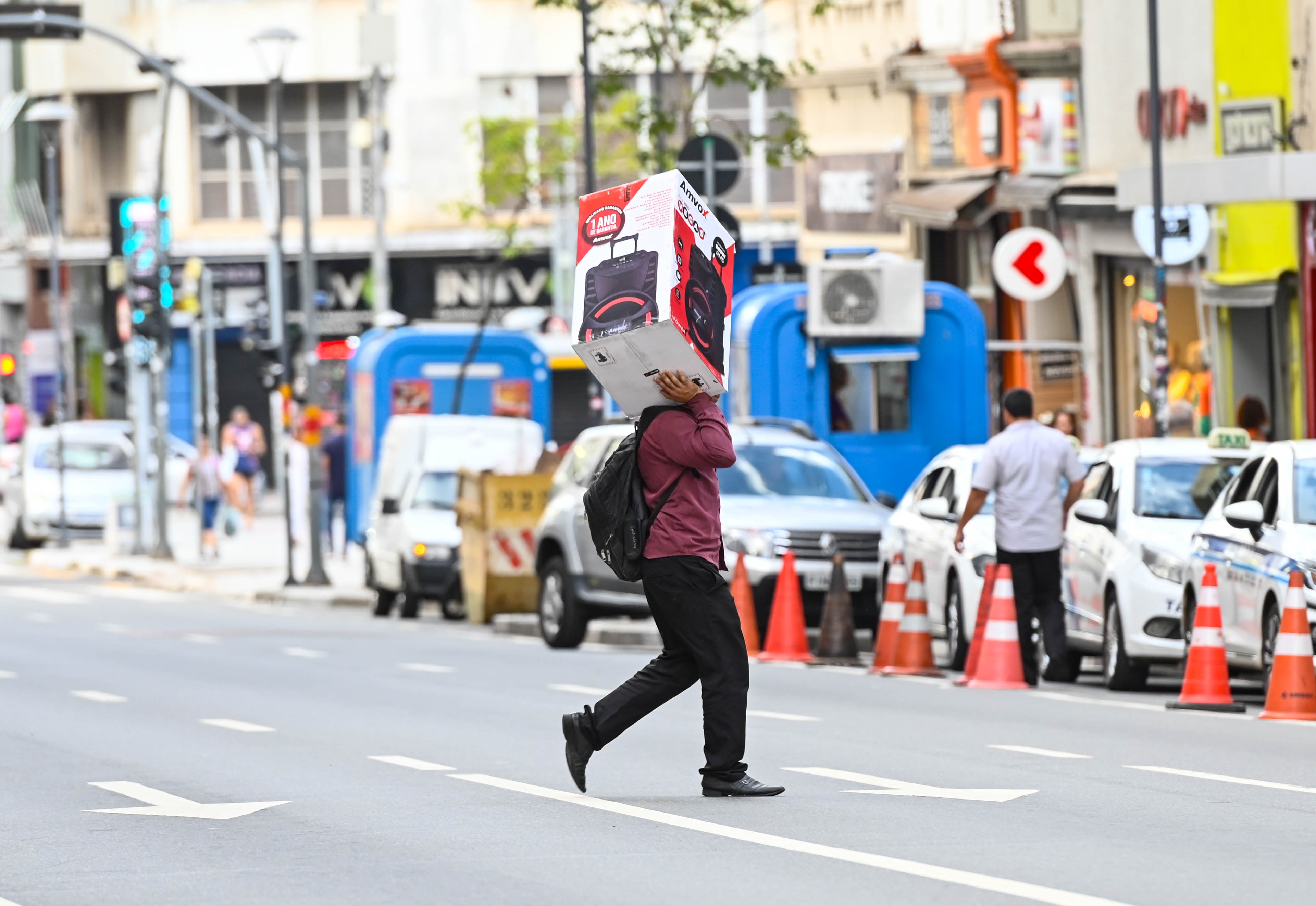 Homem carrega produto adquirido durante dia de liquidações (sexta-feira, 5/1)