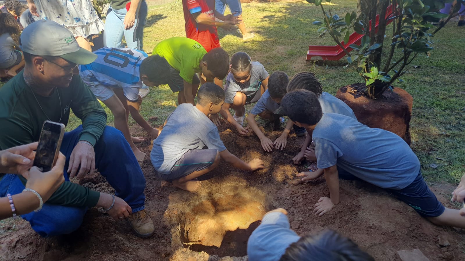 Crianças participam do plantio das árvores que, um dia, contribuirão com sombra e clima fresco para as brincadeiras no parquinho
