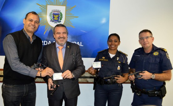 Secretário Baggio (centro) entrega os 15 revólveres calibre 38