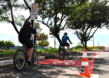 Pessoas pedalam na ciclofaixa