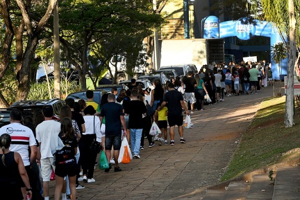 Fila para a entrada e sacolas com as doações