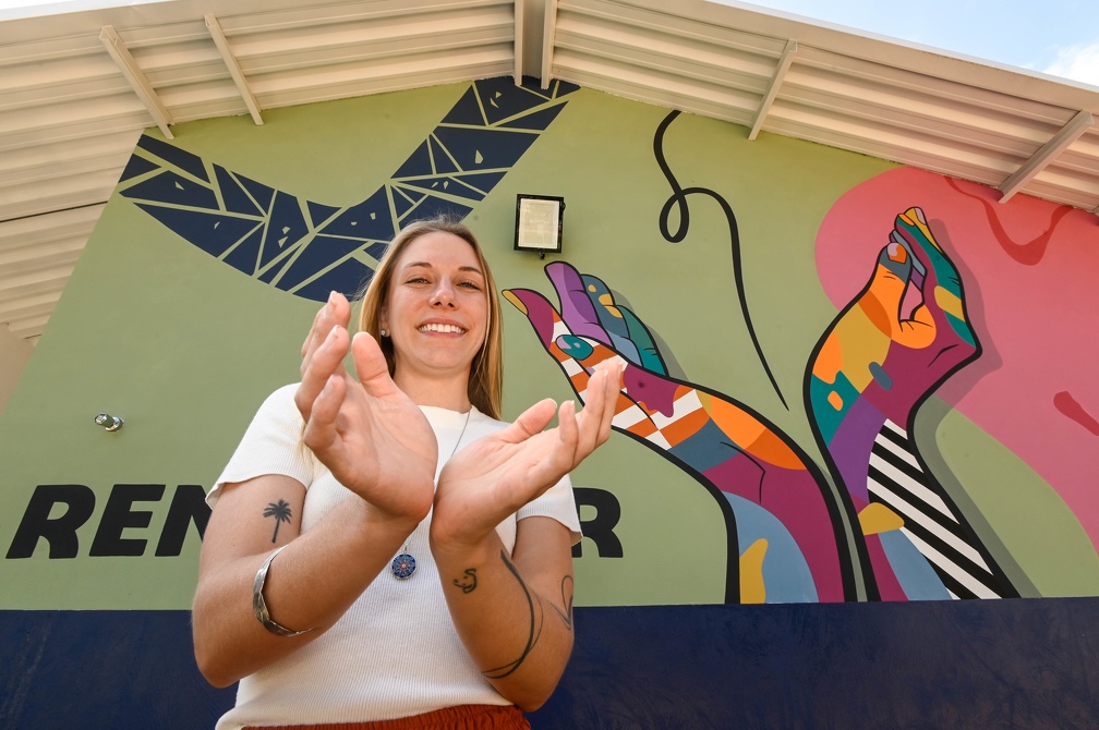 Letícia repete o gesto de acolhimento das mãos estendidas, que deixou como um presente no mural