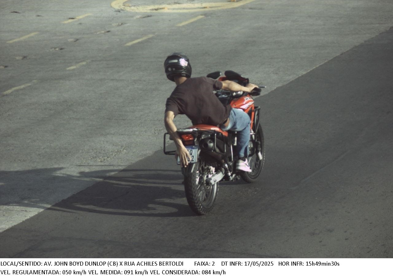 Motociclista se coloca em risco sobre a moto, em desequilíbrio, para esconder a placa