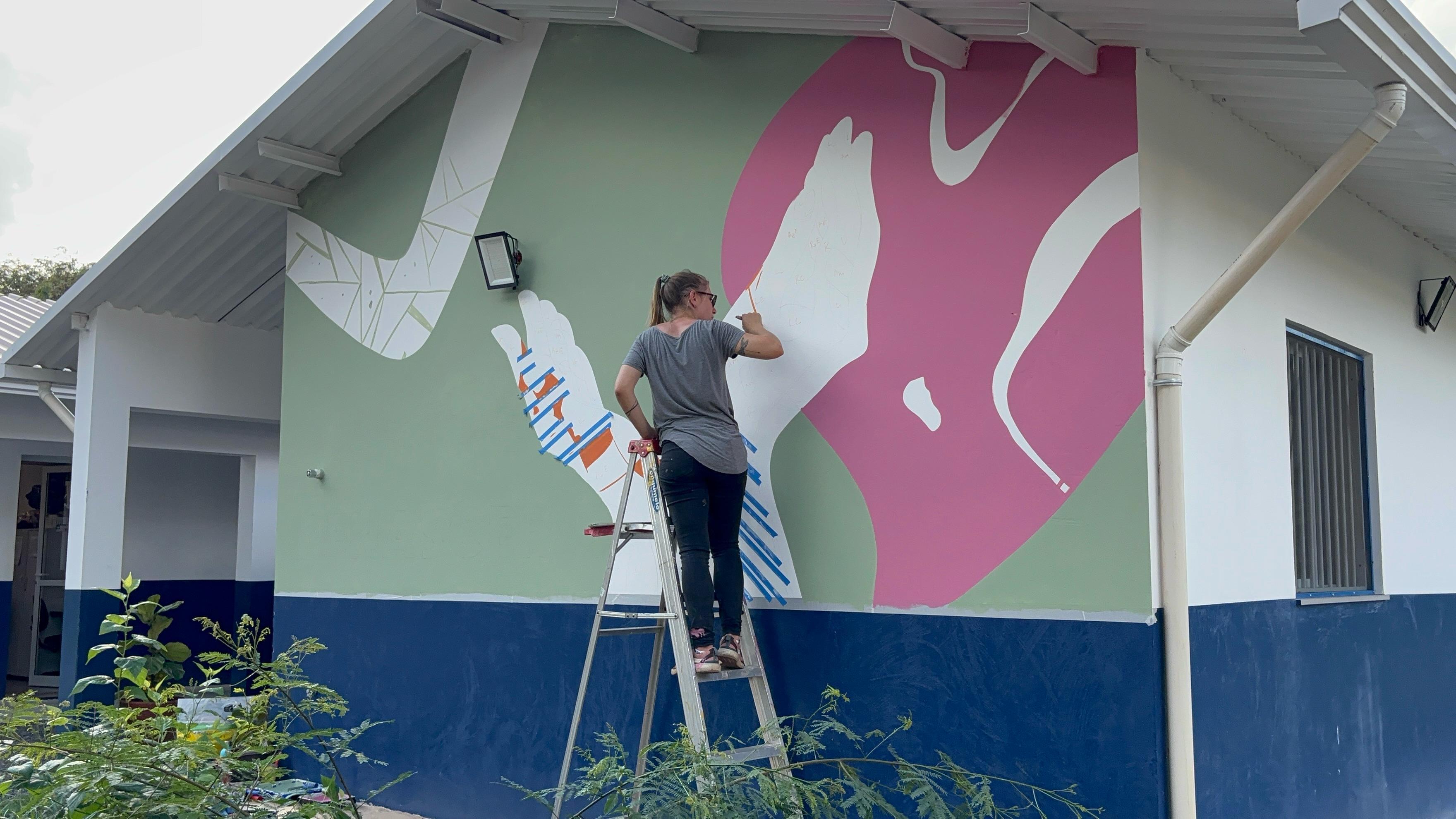 As mãos, que estarão presentes no mural como elemento visual, representam o acolhimento oferecido pelo espaço