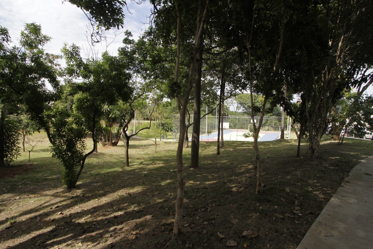 Praça arborizada com quadra e pista de caminhada