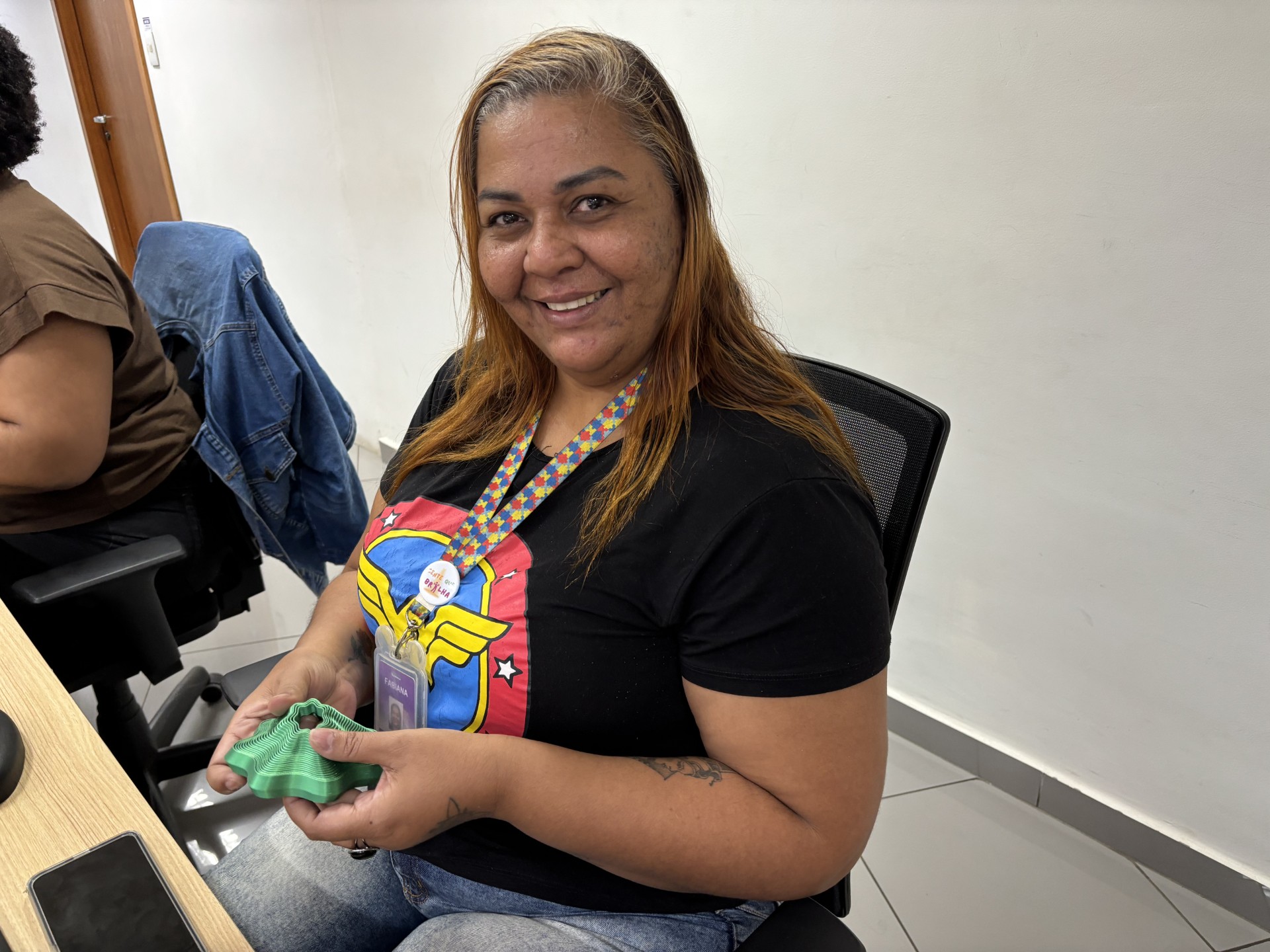 Fabiana com cordão de identificação e objeto que usa para regulação emocional quando precisa